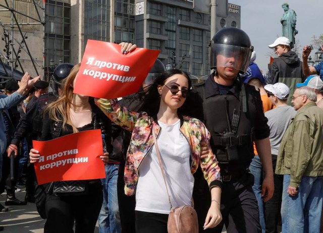 Policemen detain opposition supporters during a protest ahead of President Vladimir Putin's inauguration ceremony, Moscow, Russia May 5, 2018. The poster reads "I am against corruption". REUTERS/Tatyana Makeyeva