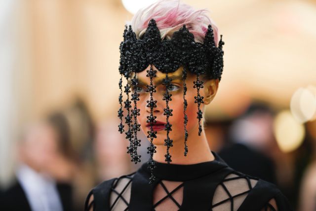 Cara Delevingne con un diseño de alta costura de Dior y un tocado negro del que caen varias tiras con pequeñas flores. REUTERS/Carlo Allegri