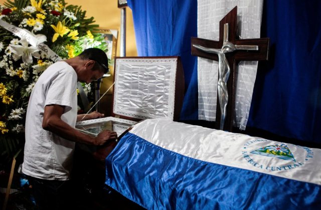 A man looks into the open coffin of  Jimmy Parajon, who was shot in recent protests against Nicaraguan President Daniel Ortega's government in Managua, Nicaragua May 11, 2018. REUTERS/Oswaldo Rivas