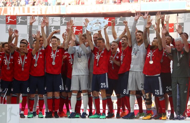 Soccer Football - Bundesliga - Bayern Munich v VfB Stuttgart - Allianz Arena, Munich, Germany - May 12, 2018 Bayern Munich's Thomas Mueller and team mates celebrate winning the Bundesliga with the trophy REUTERS/Michael Dalder DFL RULES TO LIMIT THE ONLINE USAGE DURING MATCH TIME TO 15 PICTURES PER GAME. IMAGE SEQUENCES TO SIMULATE VIDEO IS NOT ALLOWED AT ANY TIME. FOR FURTHER QUERIES PLEASE CONTACT DFL DIRECTLY AT + 49 69 650050