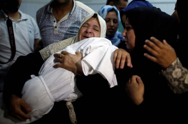ATTENTION EDITORS - VISUAL COVERAGE OF SCENES OF DEATH A relative mourns as she carries the body of 8-month-old Palestinian infant Laila al-Ghandour, who died after inhaling tear gas during a protest against the U.S. embassy move to Jerusalem, at the Israel-Gaza border, during her funeral in Gaza City May 15, 2018. REUTERS/Mohammed Salem