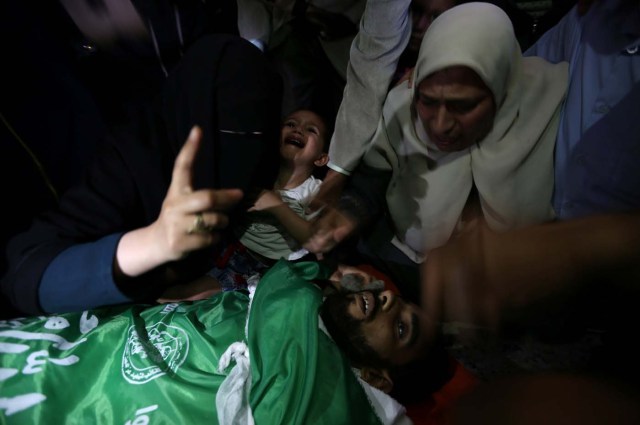 ATTENTION EDITORS - VISUAL COVERAGE OF SCENES OF INJURY OR DEATH Relatives look at the body of a Palestinian, who was killed during a protest against U.S embassy move to Jerusalem at the Israel-Gaza border, during his funeral in the central Gaza Strip May 15, 2018. REUTERS/Ibraheem Abu Mustafa TEMPLATE OUT