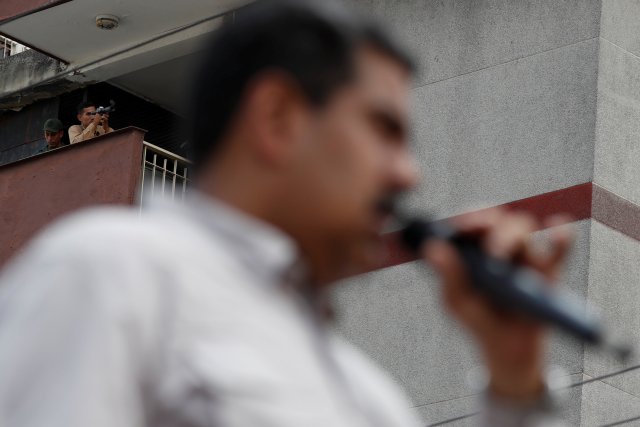  El personal de seguridad usa un monocular mientras que el presidente de Venezuela, Nicolás Maduro, pronuncia su discurso a los simpatizantes durante un mitin de campaña en Charallave, Venezuela, el 15 de mayo de 2018. REUTERS / Carlos Garcia Rawlins