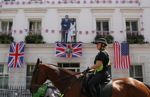 Un oficial de policía a caballo, pasa junto a un corte del Príncipe Harry y Meghan Markle, antes de su boda, en Windsor, Gran Bretaña, el 18 de mayo de 2018. REUTERS / Marko Djurica