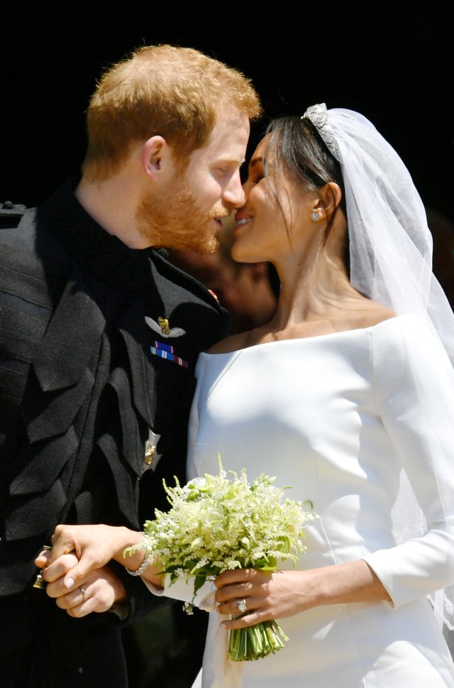 Prince Harry and Meghan Markle kiss on the steps of St George's Chapel in Windsor Castle after their wedding in Windsor, Britain, May 19, 2018. Ben Birchall/Pool via REUTERS