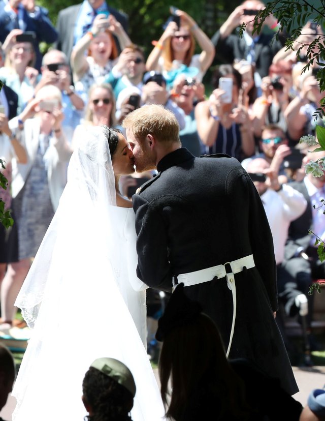 Prince Harry and Meghan Markle kiss on the steps of St George's Chapel in Windsor Castle after their wedding. Saturday May 19, 2018. Danny Lawson/Pool via REUTERS