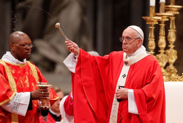 Pope Francis sprinkles holy water during a Mass of Pentecost at Saint Peter's Basilica at the Vatican, May 20, 2018. REUTERS/Remo Casilli