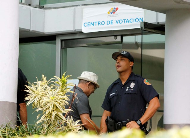 A Miami police officer stands outside the Venezuelan consulate as a citizen enters a polling place to vote in the Venezuelan presidential election in Miami, Florida, U.S., May 20, 2018. REUTERS/Joe Skipper