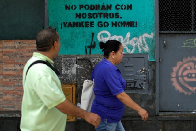 La gente pasa ante un graffiti que dice: "No podrás hacerlo con nosotros. Yankee ve a casa" en el centro de Caracas, Venezuela, 21 de mayo de 2018. REUTERS / Marco Bello