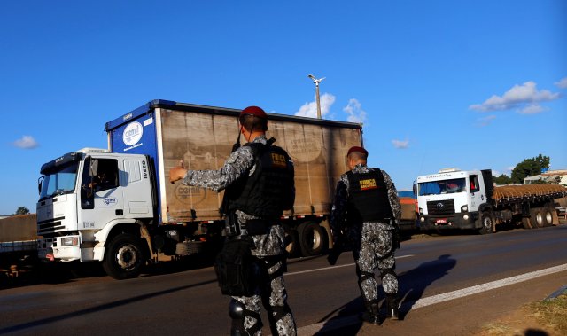 Police officers order truckers to clear the blocked BR-04 highway in Luziania, Brazil May 26, 2018. REUTERS/Adriano Machado