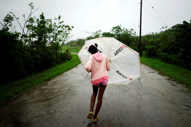 REFILE - CORRECTING GRAMMAR Dalma Samora, 14, walks against the winds of Subtropical Storm Alberto as it passes by the west coast of Cuba, in La Palma, Cuba, May 26, 2018. REUTERS/Alexandre Meneghini