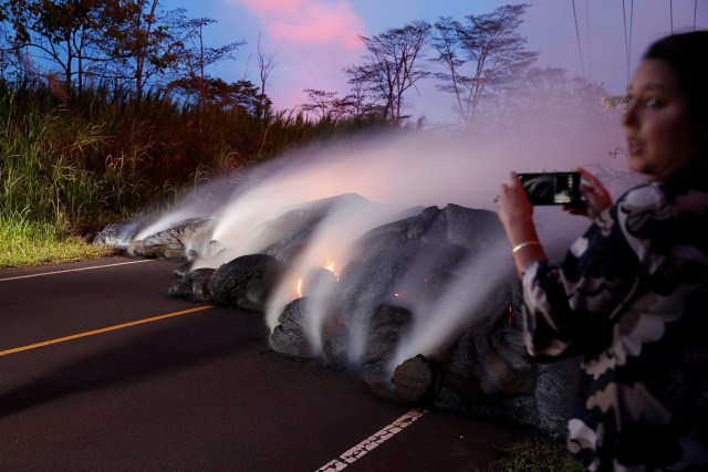 Una reportera fotografía el avance de la lava del volcán Kilauea por la Carretera de Pohoiki, cerca de la Autopista 132, cerca de Pahoa, Hawái, Estados Unidos. 28 mayo 2018. REUTERS/Marco Garcia