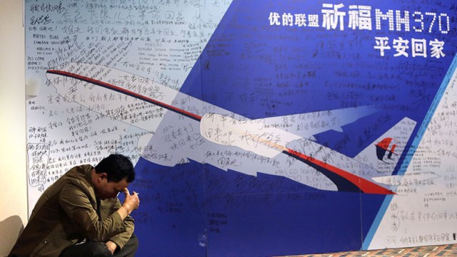 El hermano de un pasajero del vuelo MH370 cerca de un panel de mensajes dedicados a los pasajeros del vuelo desaparecido, Pekín, el 29 de marzo de 2014. Jason Lee / Reuters