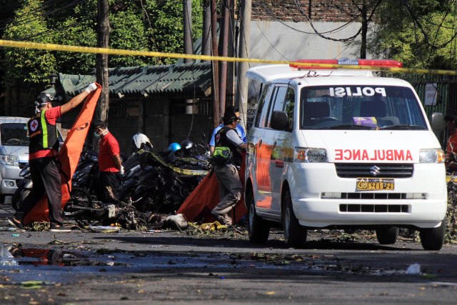 BY07. Surabaya (Indonesia), 13/05 / 2018.- Agentes de la policía indonesia llevan bolsas de cadáveres en la escena de la explosión de una bomba frente a una iglesia en Surabaya, Java Oriental, Indonesia, el 13 de mayo de 2018. Según informes de prensa, al menos once personas han muerto y docenas más han resultado heridas después de que ocurrieron explosiones de bombas en tres lugares en Surabaya. EFE / EPA / STRINGER 