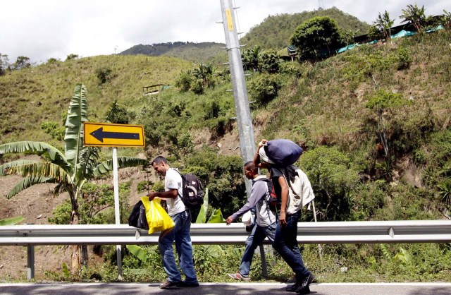  COLOMBIA VENEZUELA. CUC301. CÚCUTA (COLOMBIA), 24/05/2018.- Fotografía fechada el 22 de Mayo de 2018 que muestra al venezolano Anthony Bogado (i), de 35 años, acompañado de un primo de 43 y un sobrino de 18, con quienes lleva dos días caminando por la vía Cúcuta - Pamplona en la población de Los Patios (Colombia). Atravesar parte de Colombia a pie es el desafío que afrontan a diario decenas de venezolanos que, sin dinero para el transporte, se aventuran desde la frontera por las carreteras del país para llegar a ciudades del interior en busca de trabajo y futuro. EFE/Schneyder Mendoza