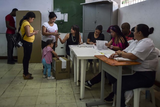 Women votes at a polling station in Cali, Valle del Cauca Department, during presidential elections in Colombia on May 27, 2018. Voters went to the polls Sunday to choose a new president of Colombia in a divisive election that is likely to weigh heavily on the future of the government's fragile peace deal with the former rebel movement FARC. / AFP PHOTO / Luis ROBAYO