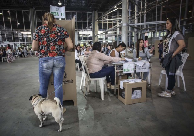 A woman votes at a polling station in Medellin, Antioquia Department, during the first round of the presidential election in Colombia on May 27, 2018. Voters went to the polls Sunday to choose a new president of Colombia in a divisive election that is likely to weigh heavily on the future of the government's fragile peace deal with the former rebel movement FARC. / AFP PHOTO / Joaquin SARMIENTO