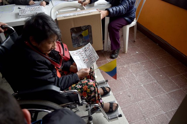 A woman in wheelchair votes at a polling station in Bogota during the first round of the presidential election in Colombia on May 27, 2018. Voters went to the polls Sunday to choose a new president of Colombia in a divisive election that is likely to weigh heavily on the future of the government's fragile peace deal with the former rebel movement FARC. / AFP PHOTO / Diana SANCHEZ
