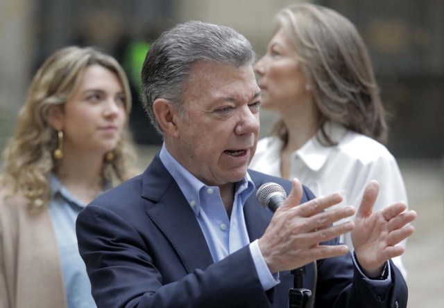 Colombian President Juan Manuel Santos, accompanied by his daughter Maria Antonia (L) and wife Maria Clemencia, speaks to the press after casting his vote at a polling station in Bogota during presidential elections in Colombia on May 27, 2018. / AFP PHOTO / John VIZCAINO