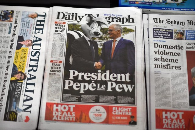 A copy of The Daily Telegraph is seen on a newstand with a nearly full-page photo of French President Emmanuel Macron with the cartoon head of Pepe le Pew, the lovelorn French skunk, in Sydney on May 3, 2018. Macron on May 3 laughed off global amusement after he described the wife of Australian Prime Minister Malcolm Turnbull as "delicious" during a visit to Sydney. / AFP PHOTO / SAEED KHAN