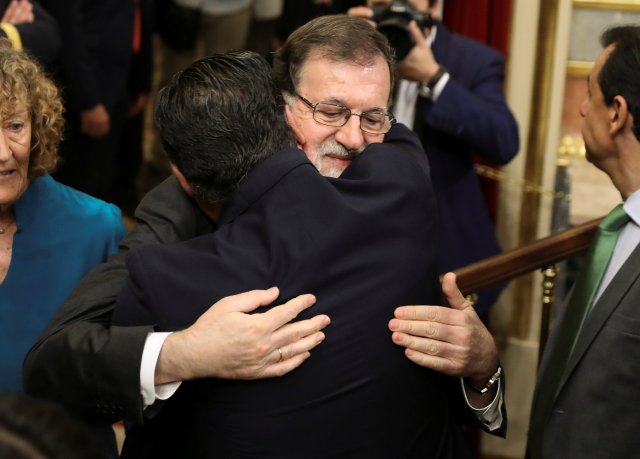 El primer ministro de España, Mariano Rajoy, abraza a un diputado del partido en el Parlamento antes de la votación sobre una moción de no confianza en Madrid, España, el 1 de junio de 2018. REUTERS / Sergio Pérez