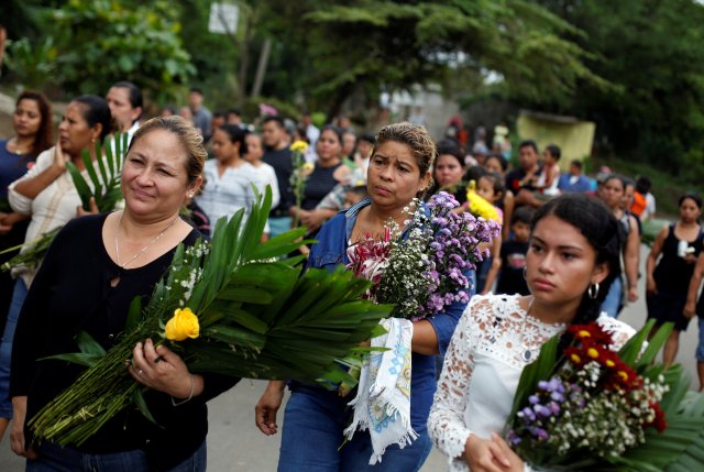 People hold flowers as they arrive to the grave of the student Chester Chavarria, 19, who was killed during a protest against Nicaraguan President Daniel Ortega's government, at the cemetery in Managua, Nicaragua June 9, 2018. REUTERS/Jorge Cabrera