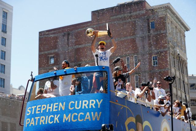 JGM02. OAKLAND (EE.UU.), 12/06/2018.- El jugador de los Golden State Warriors Stephen Curry (c) sostiene el Trofeo Larry O'Brien durante el desfile de la victoria en honor a los recientes campeones de la NBA hoy, martes 12 de junio de 2018, en el centro de Oakland (EE.UU.). Los Warriors vencieron a los Cleveland Cavaliers en las finales de la NBA, obteniendo así su segundo título consecutivo y el tercero de las últimas cuatro finales, lo que puso al equipo a las puertas de ser la nueva dinastía en el mejor baloncesto del mundo. EFE/John G. Mabanglo