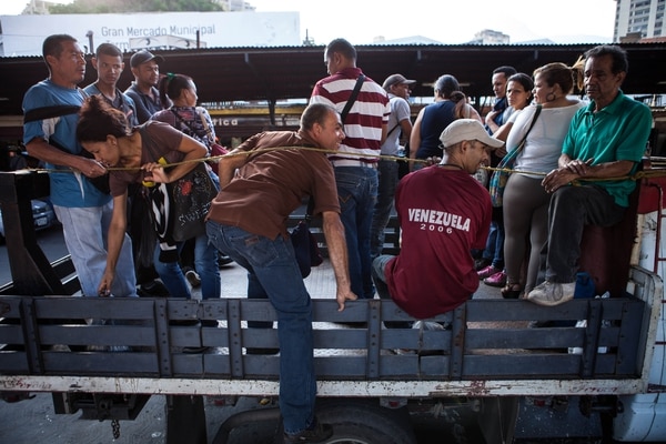Las cajas de diferentes tipos de camiones y pick ups se han vuelto un transporte informal habitual en las calles de las principales ciudades venezolanas (foto infobae.com)