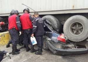 Dos vehículos quedaron atrapados bajo una gandola tras accidente en la autopista de Valencia (fotos y videos)