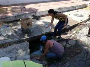 Vecinos de Palo Verde recogen agua estancada en un pozo en plena calle (FOTOS + VIDEOS)