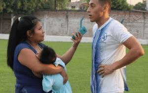 Periodista realiza cobertura de un partido de fútbol llevando a su bebé en brazos (Fotos)
