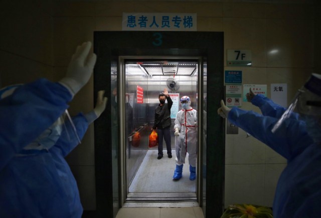 El personal médico se despidió de un paciente con coronavirus COVID-19 recuperado en el Hospital de la Cruz Roja en Wuhan, en la provincia central china de Hubei, el 16 de marzo de 2020. – China informó 12 casos más importados del nuevo coronavirus el 16 de marzo a medida que la capital endureció las medidas de cuarentena para llegadas internacionales para prevenir una nueva ola de infecciones. (Foto por STR / AFP) / China OUT