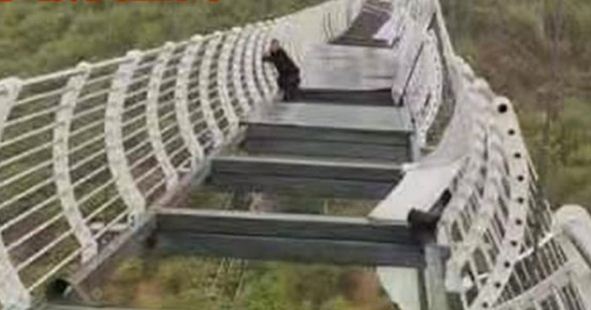 Quedó colgando a 100 metros luego que se quebrara un puente de vidrio en China (Fotos)