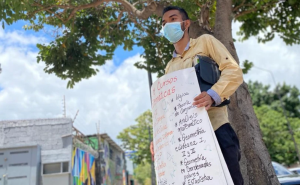 Con cartel en mano, aspirante a profesor camina por Caracas ofreciendo clases (Video)