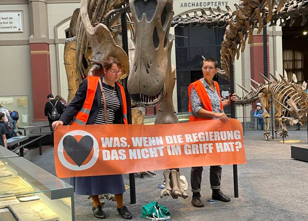 Otra polémica protesta incluyó dos ambientalistas, pega loca y huesos de dinosaurio
