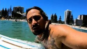 Australia multa a un hombre por surfear con una serpiente pitón enrollada en su cuello